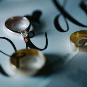 Elegant wedding rings placed on an invitation card with stylized script, symbolizing romance.